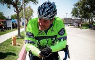 man rests with his bicycle