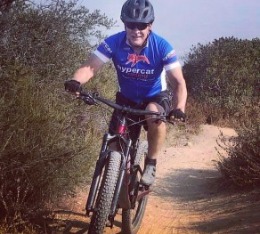 John rides his mountain bike down a dirt trail