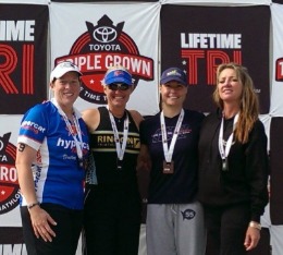 4 Female athletes pose on stage after Lifetime Triathlon