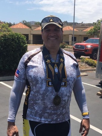 Man smiles with medal earned around his neck