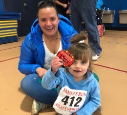 Mom and daughter pose with finisher medal.