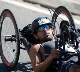 Man racing in a handcycle in a half-ironman triathlon.