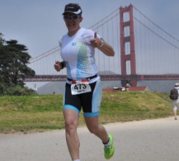 Female athletes gives thumbs up during run in triathlon